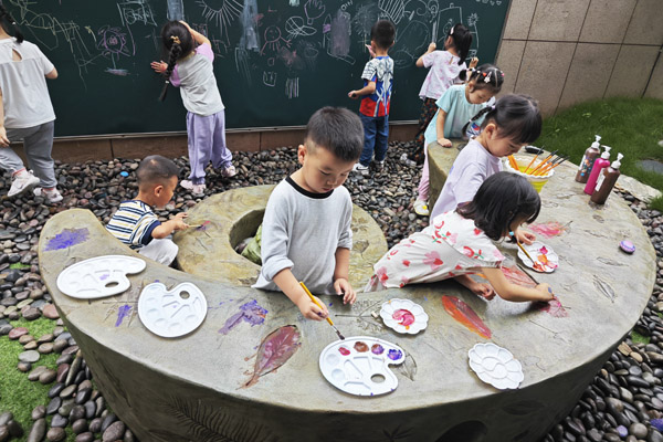 孩子們創作樹葉拓印水泥桌現場。二師附二幼供圖